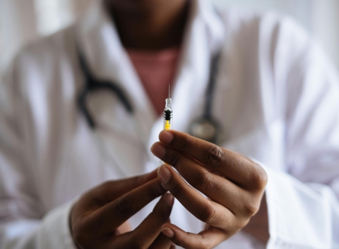 IMAGE OF A DOCTORE HOLDING VACCINATION SYRINGE