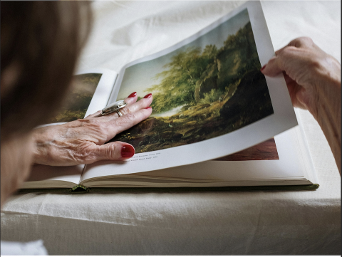 Elderly person looking through photo album